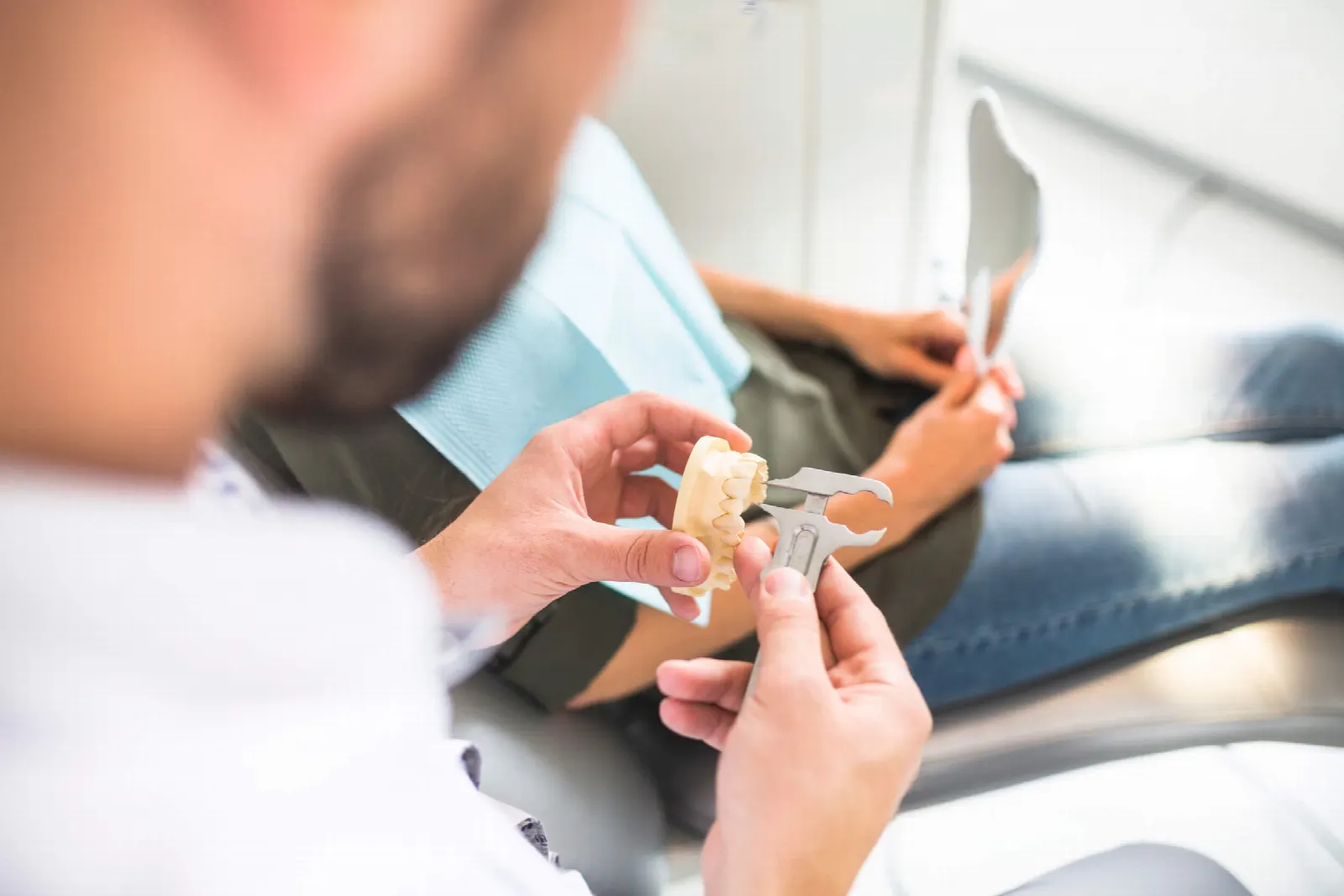 Dentist measuring a tooth model before implant placement