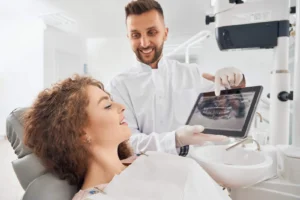 Dentist showing a patient the all-on-4 implant plan on a tablet