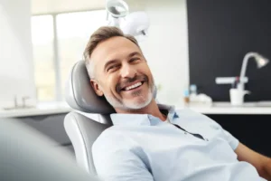 Happy patient in the dental chair after a complete dental reconstruction