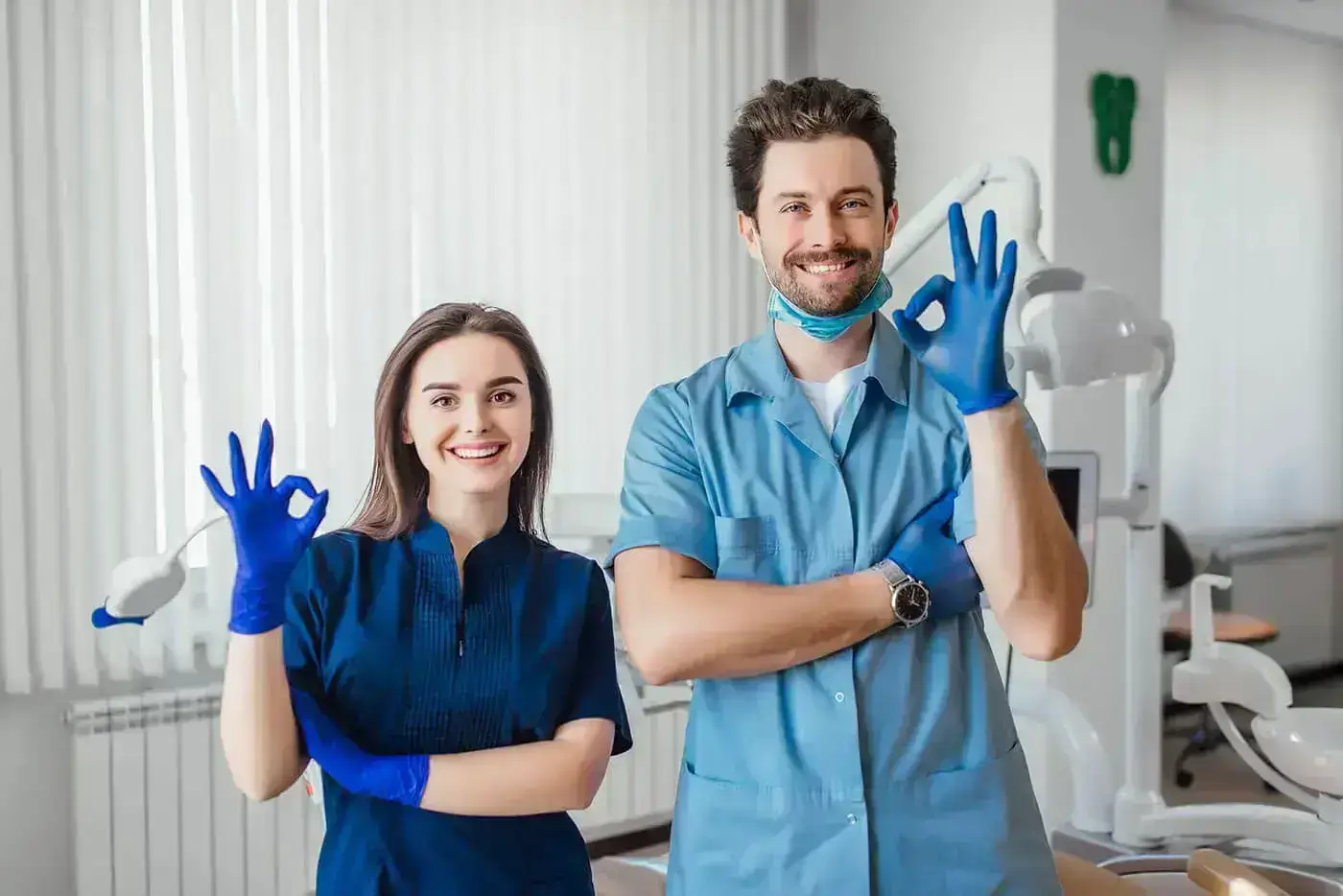 Zubný lekár a asistentka ukazujú gesto OK v ambulancii HAPPYDENT