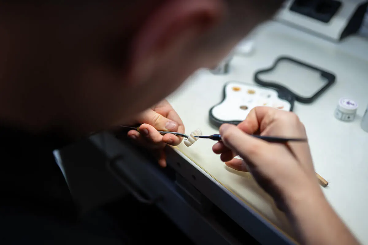 Zubný technik dotvára korunku v laboratóriu HAPPYDENT LAB