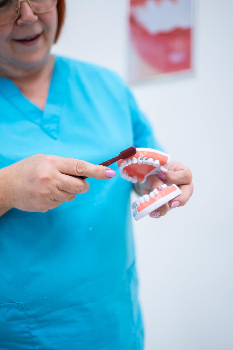 dentálna hygienička ukazuje ako správne čistiť zuby